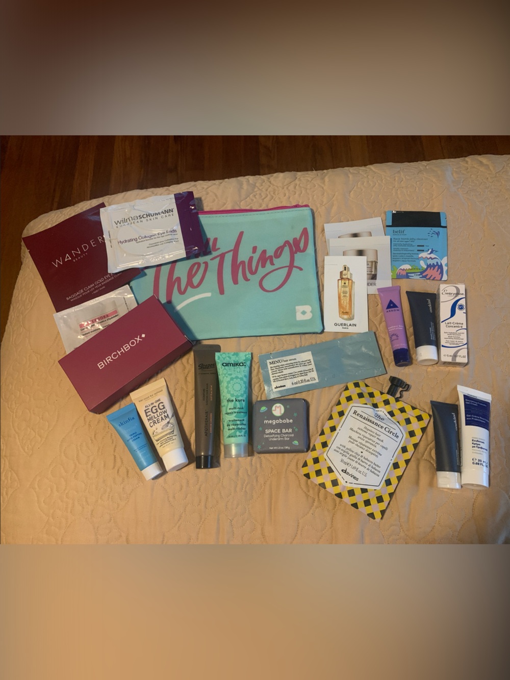 Assorted hair and skincare samples with makeup bag